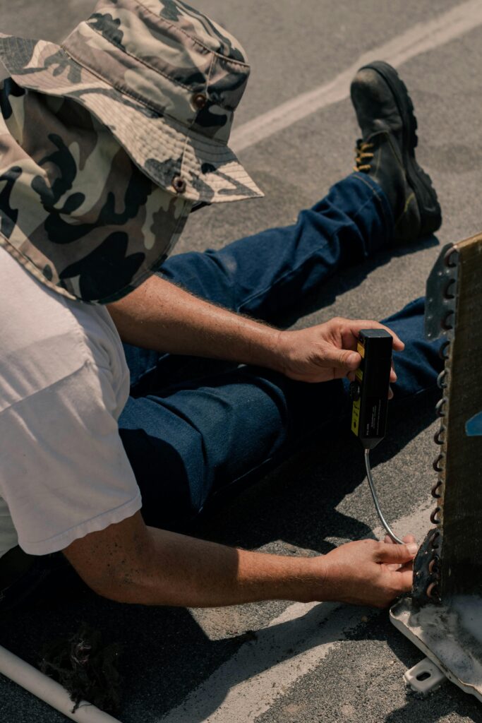 Manual laborer repairing air conditioning unit outdoors in Cancún.